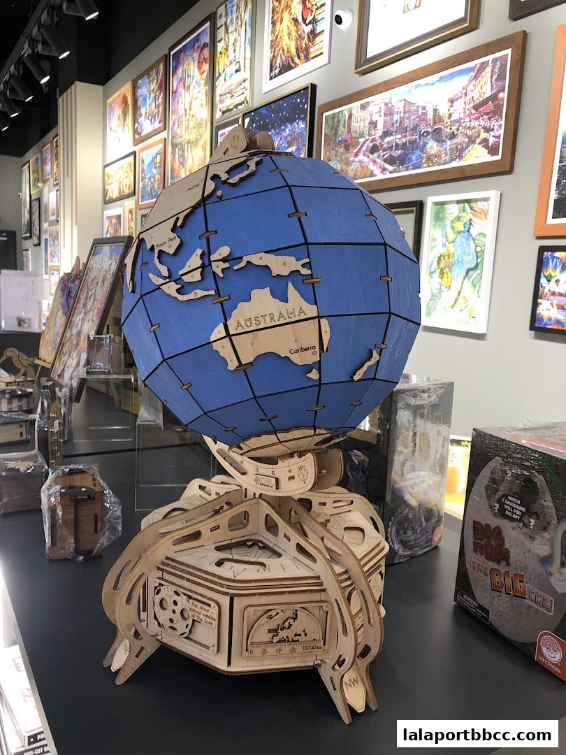 A wooden 3D puzzle globe and other puzzle boxes displayed in a shop.