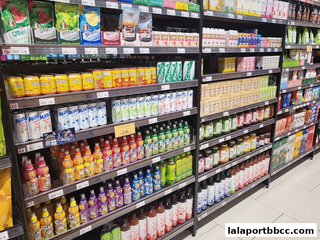 Shelves stocked with various beverages, including juices, milk, and sodas, in a grocery store.