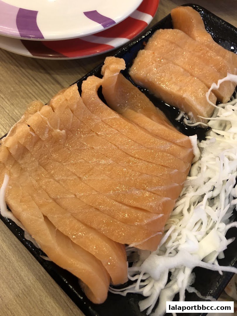 A close-up shot of fresh salmon sashimi served with shredded cabbage.