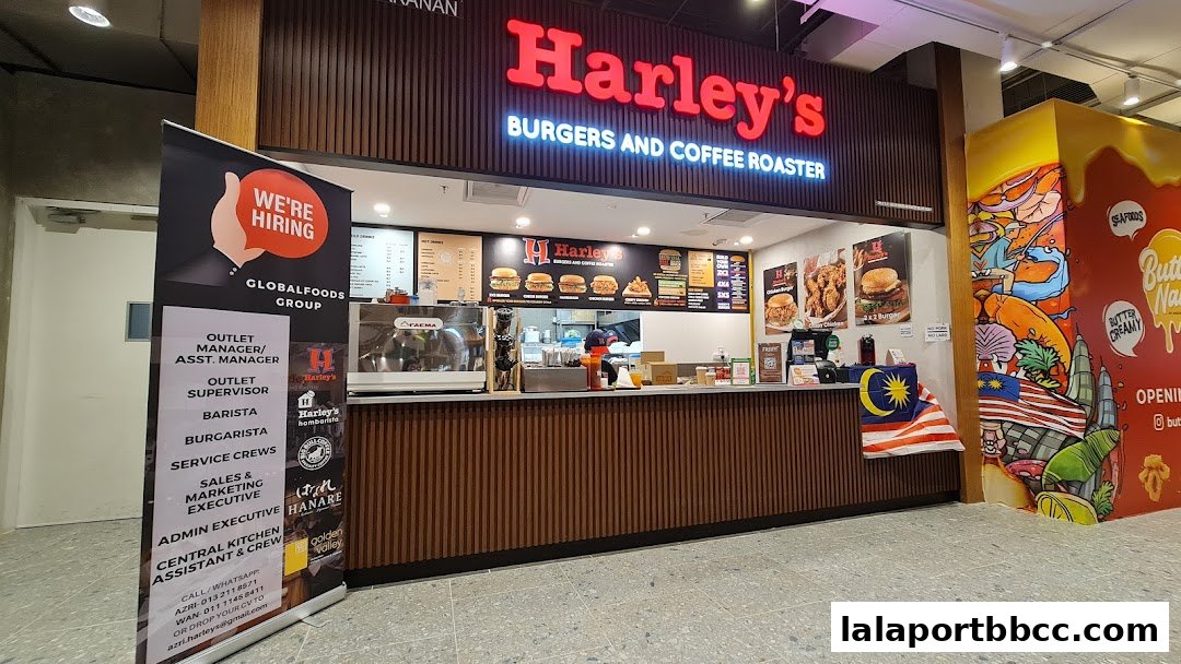 A food court stall named Harley's Burgers and Coffee Roaster with a hiring banner and colorful mural.
