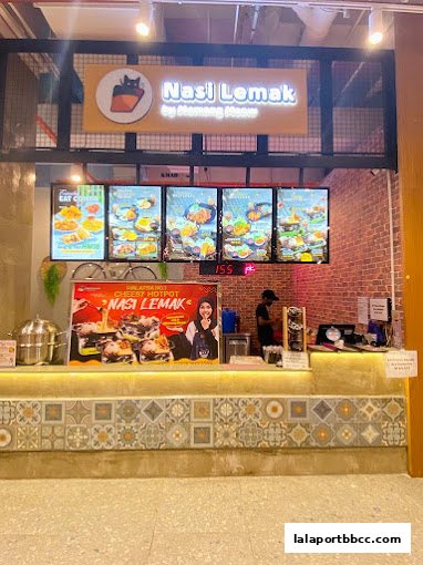 A Nasi Lemak shop with illuminated menu boards and a promotional poster.