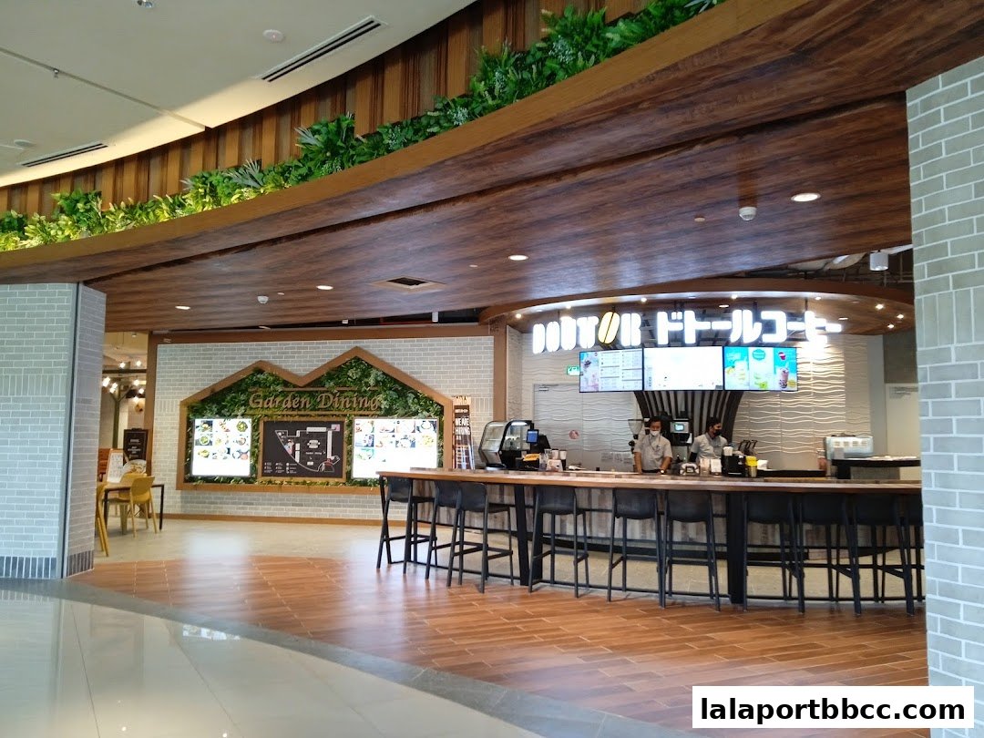 Interior view of a DOUTOR COFFEE shop with a counter, seating, and menu displays.