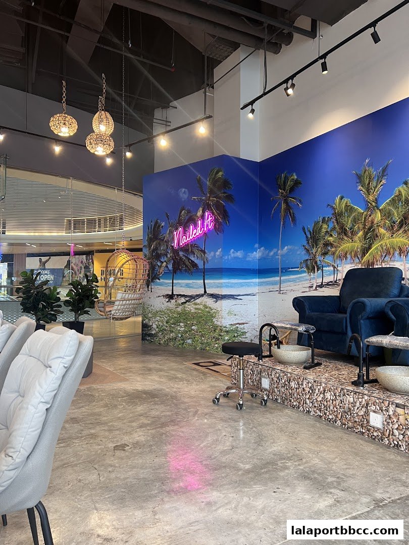 Interior of a nail salon with pedicure chairs and a tropical beach mural.