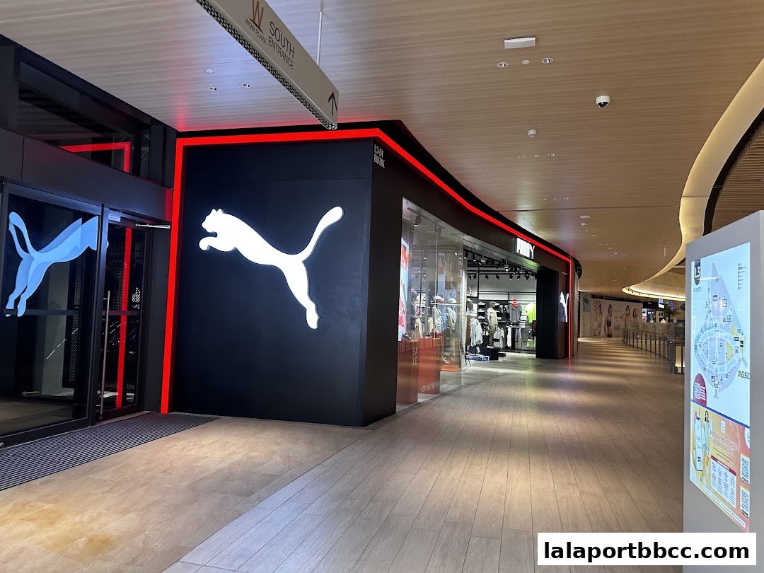 The PUMA store entrance with its iconic leaping cat logo and red neon accents.