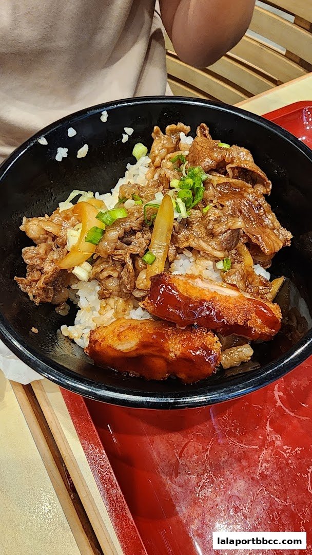 A close-up of a delicious Sukiya Tokyo Bowl with beef, chicken, and rice.