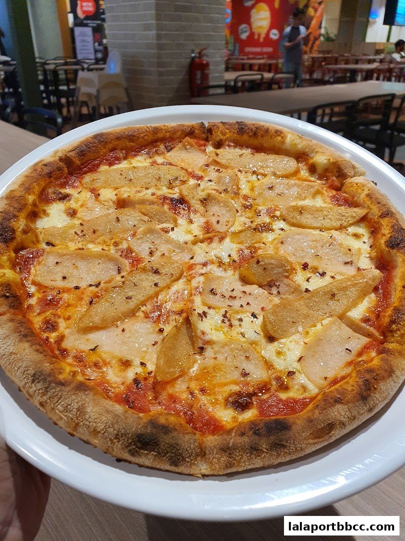 A close-up shot of a delicious pizza with pear slices and cheese on a white plate.