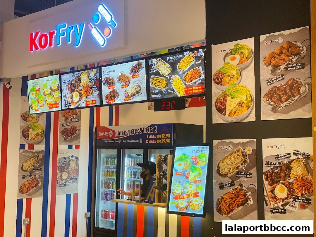 A KorFry shop with illuminated menu boards and posters showcasing fried chicken and other dishes.