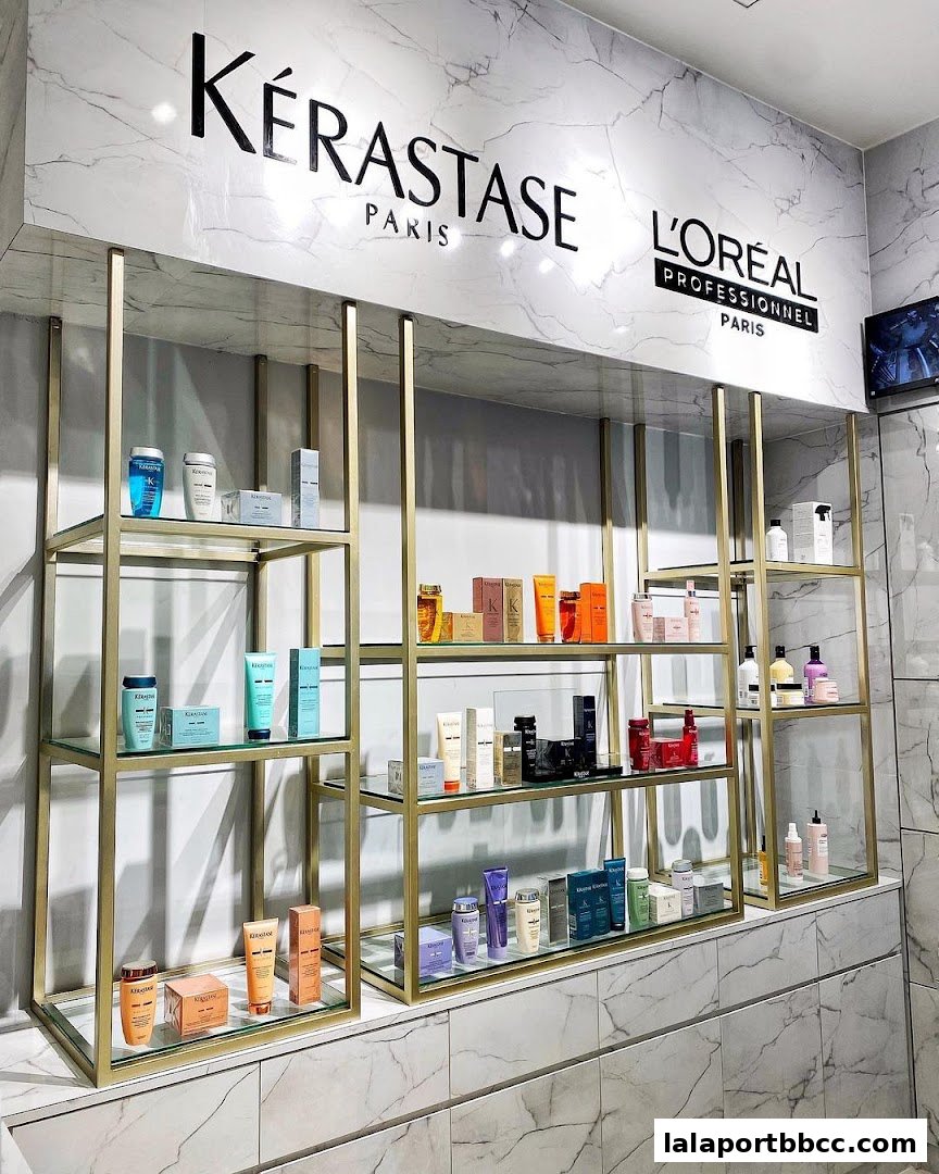 A display of Kérastase and L'Oréal hair products on shelves with marble-patterned walls.