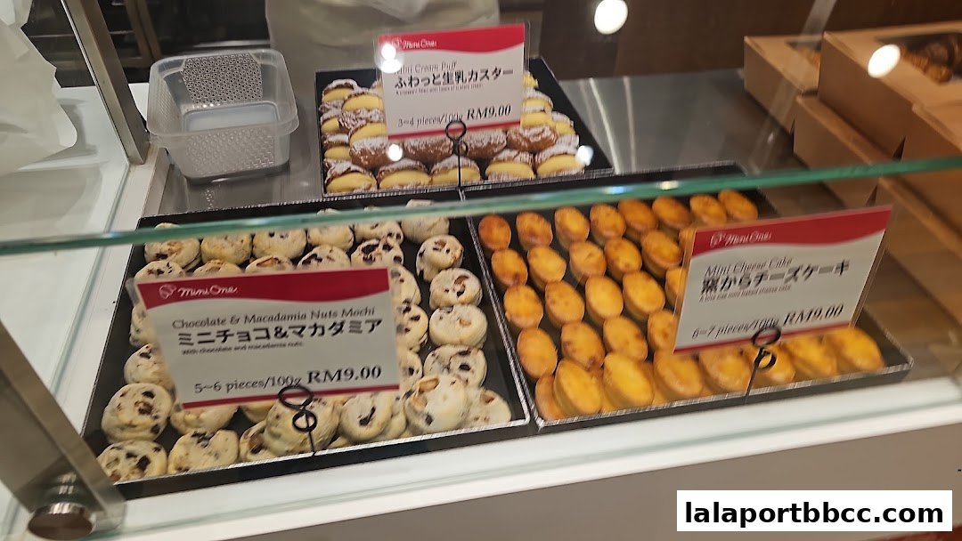 A display case filled with various baked goods, including mochi and mini cheese cakes.