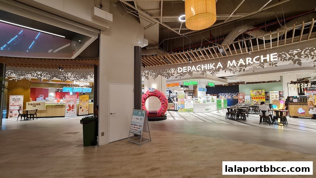 A wide view of a bustling food hall with various eateries and seating areas.