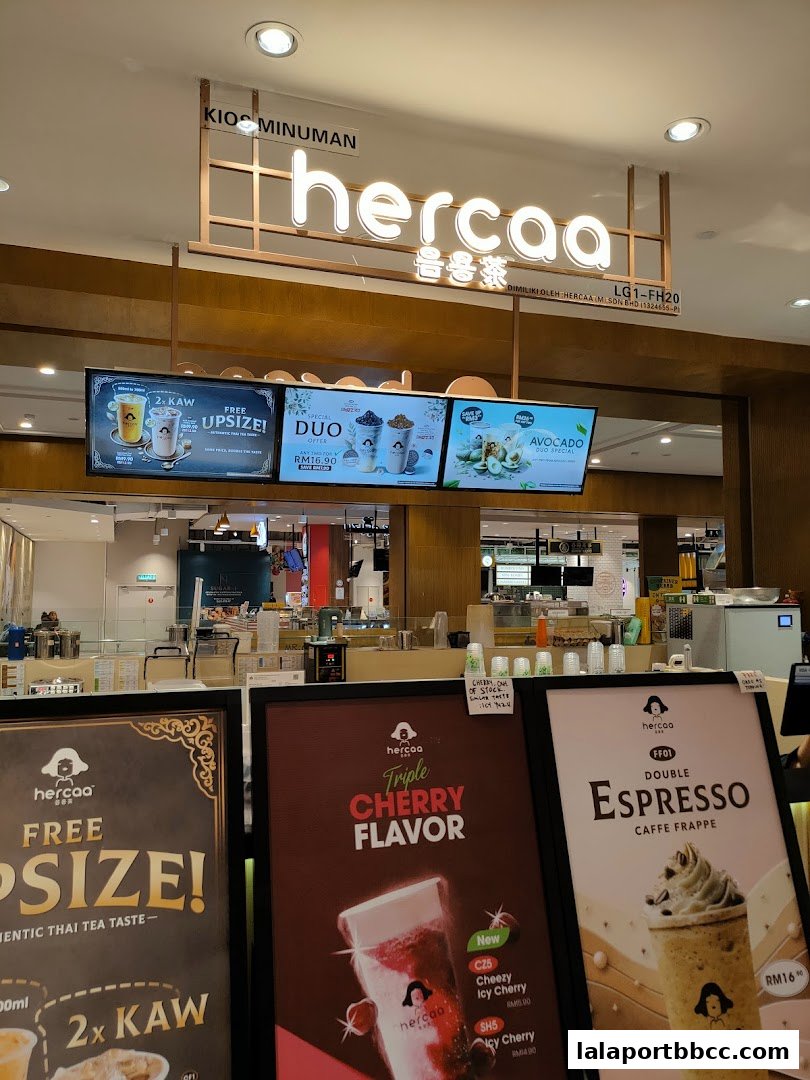 The front of a Hercaa beverage shop with illuminated signage and promotional displays.