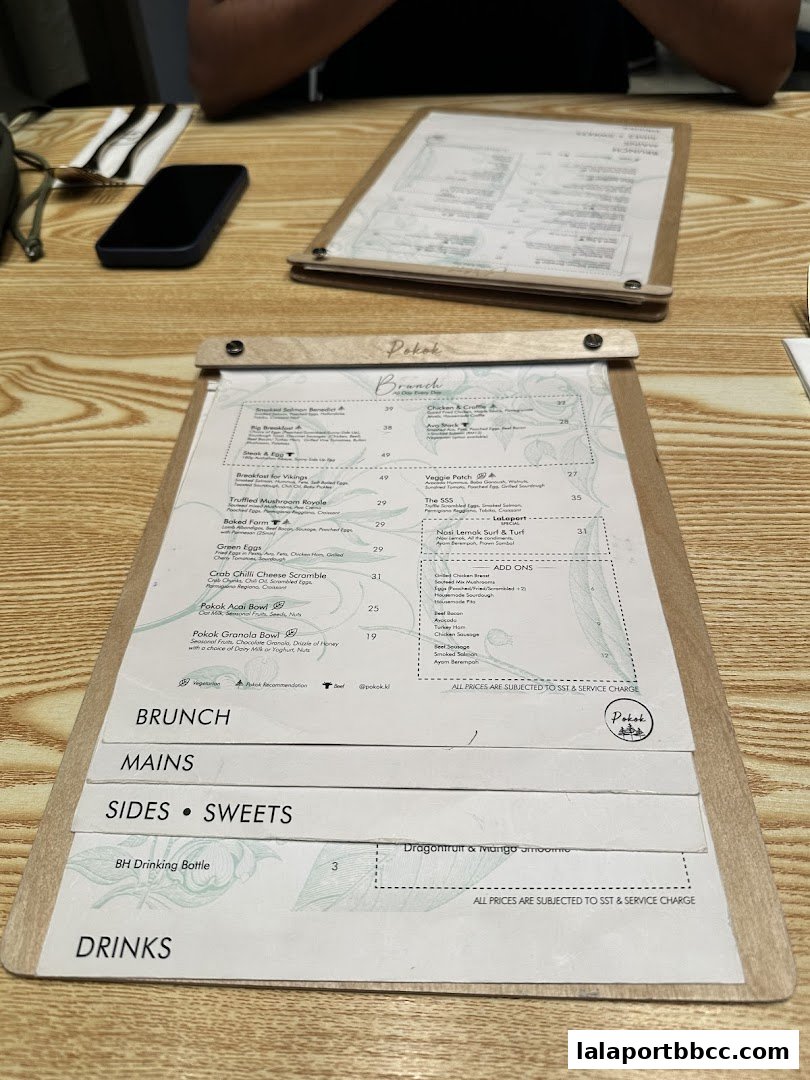 A menu from POKOK LaLaport featuring brunch, mains, sides, sweets, and drinks.