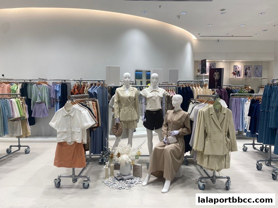 Mannequins display stylish outfits in a well-lit fashion boutique with clothing racks.