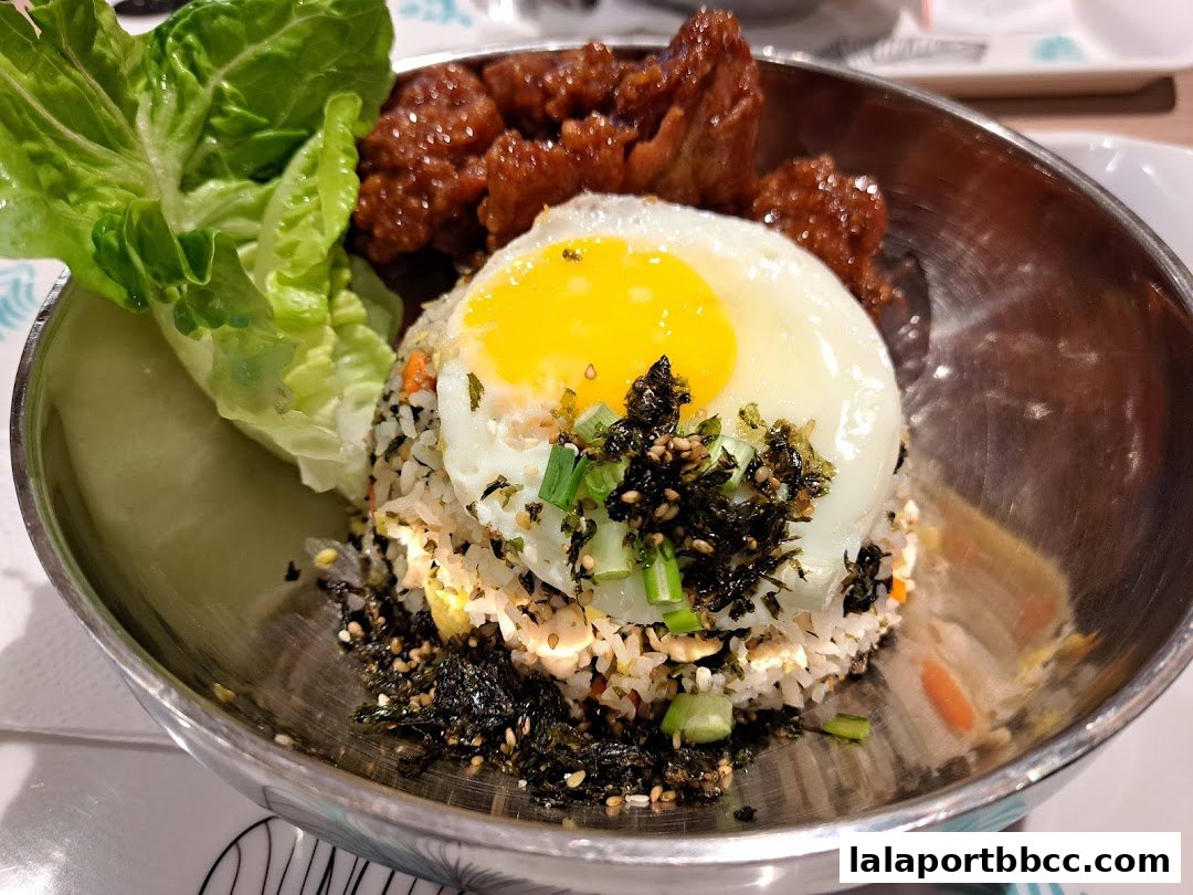 A delicious Korean fried chicken and rice dish with a fried egg and lettuce.
