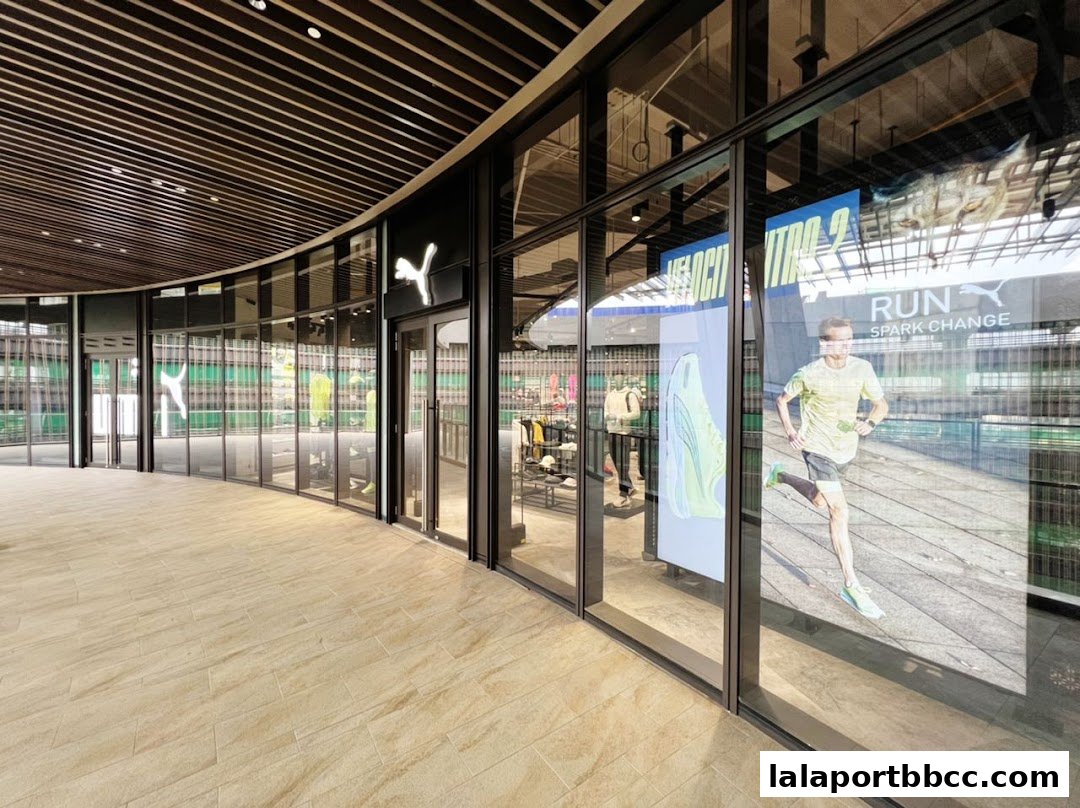 The modern storefront of a PUMA shop with large glass windows displaying athletic wear and a runner.