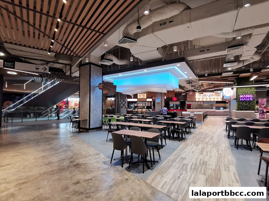 A spacious cafeteria area with multiple food stalls and seating arrangements.