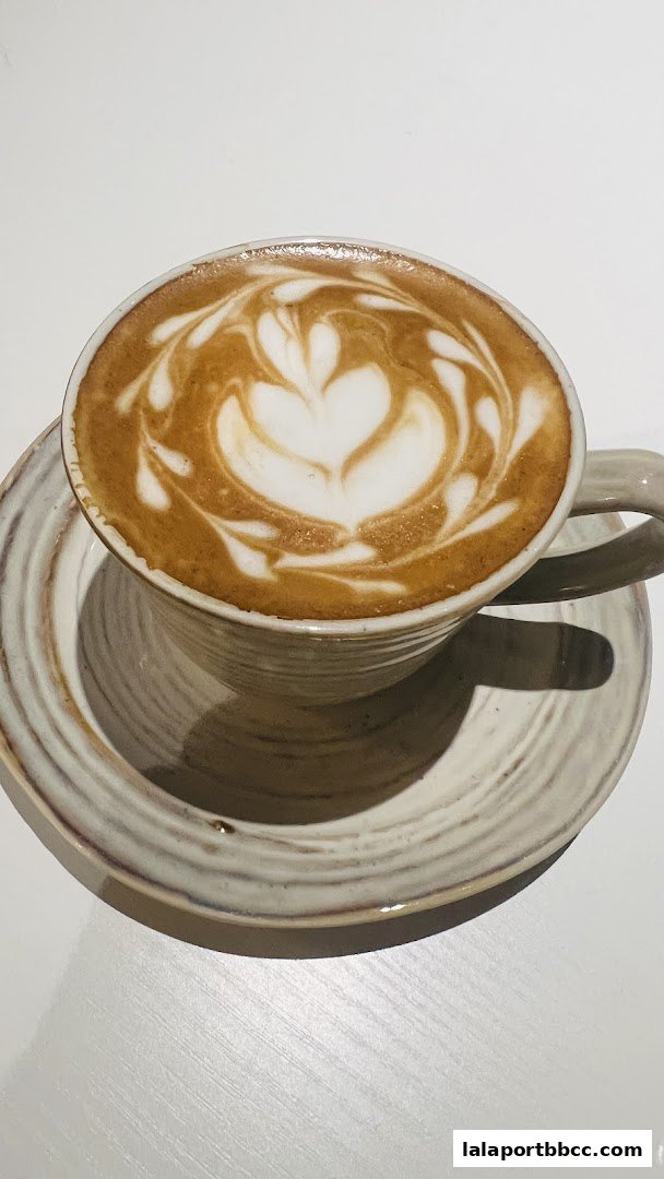 A close-up shot of a latte with intricate latte art in a ceramic cup and saucer.