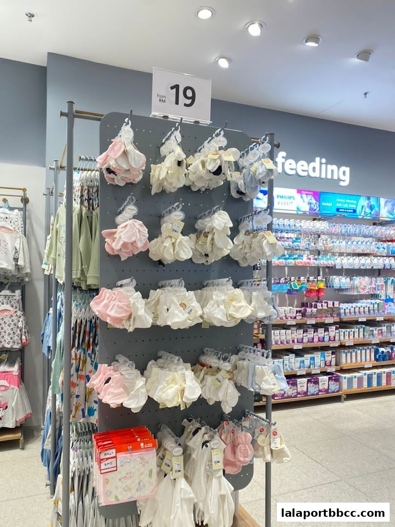 A display of baby clothing and accessories, including socks and bibs, in a retail store.