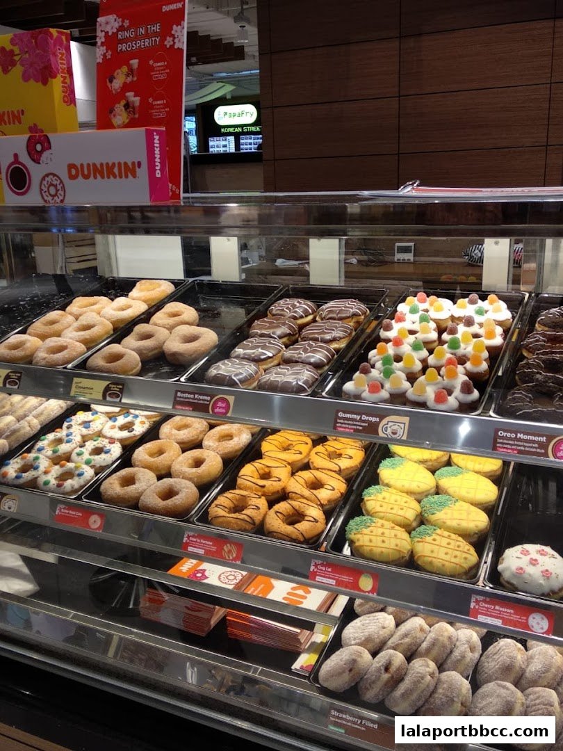 A display case filled with various donuts and pastries from Dunkin'.