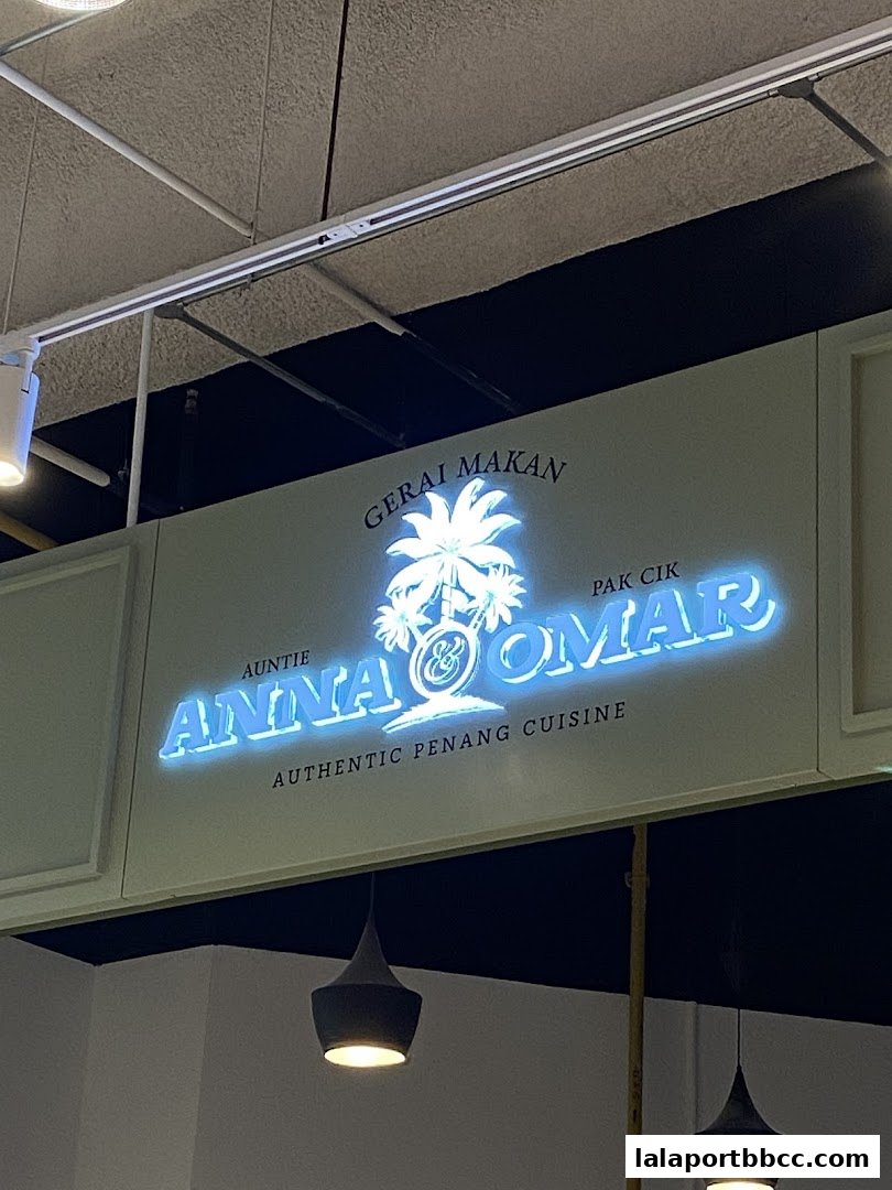 A glowing neon sign for Auntie Anna Pak Cik Omar, advertising authentic Penang cuisine.