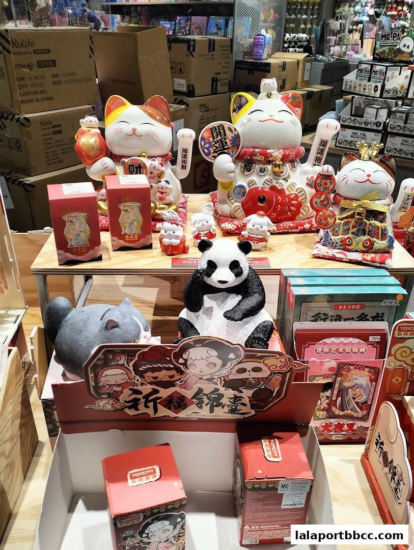 A display of various decorative items including lucky cats, a panda, and collectible figures.