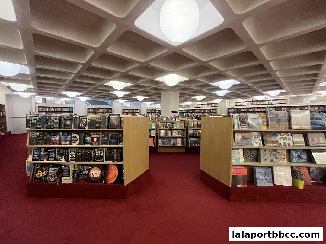 Interior view of a spacious bookstore with shelves full of books and a red carpet.