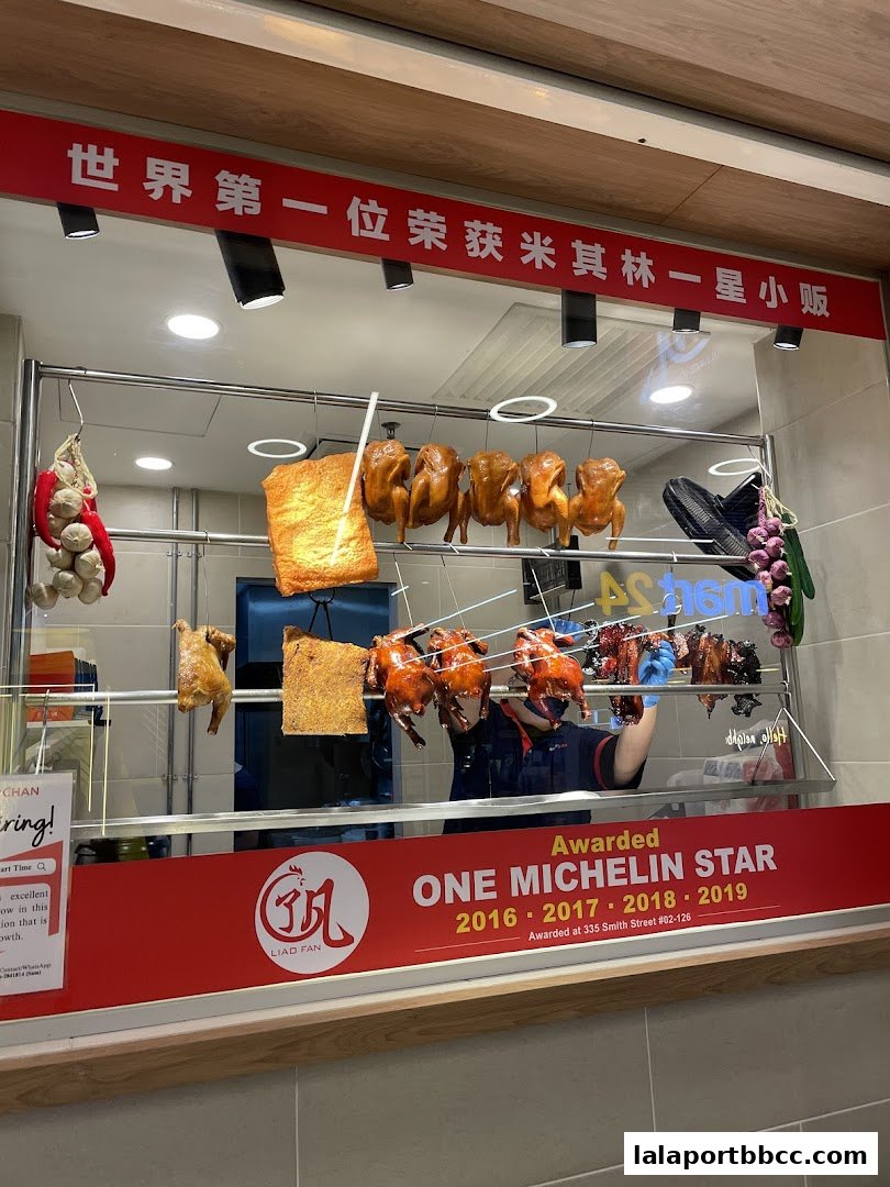 Hanging roasted chickens and pork, with a sign indicating Michelin star awards.
