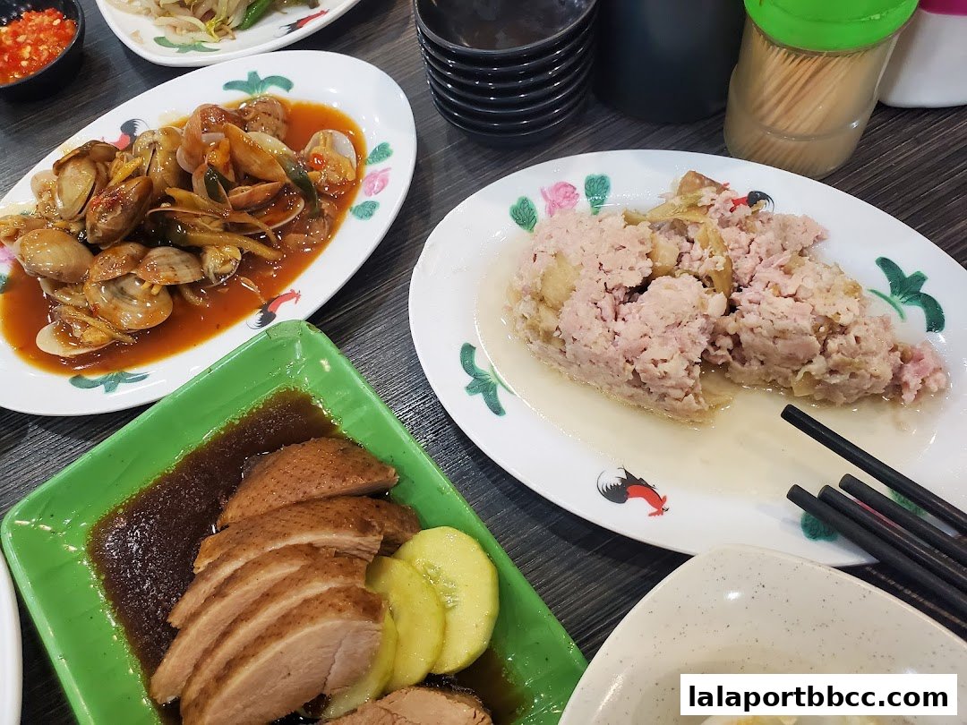 A table laden with delicious Teochew dishes, including clams, minced pork, and roasted duck.
