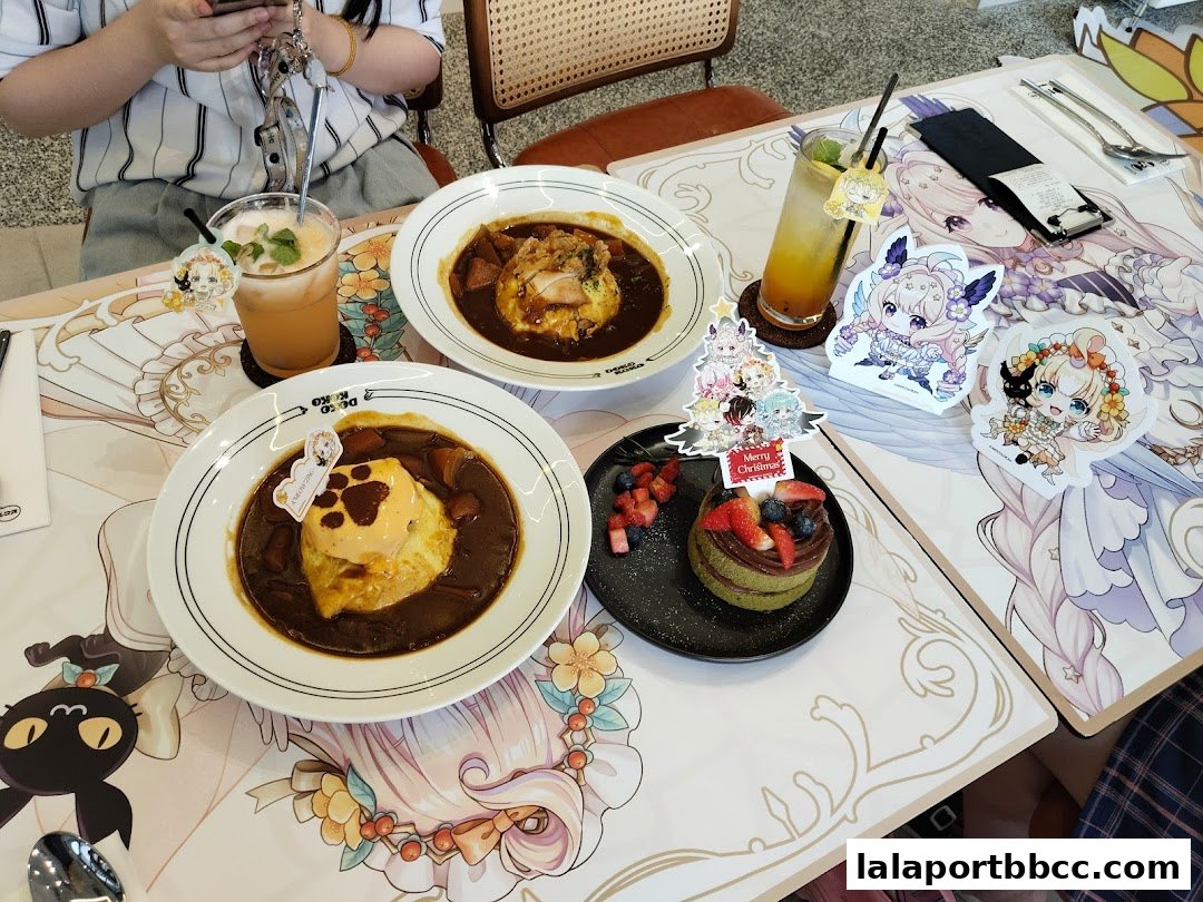 A table setting at Doko Koko with two curry rice dishes, a dessert, and drinks.