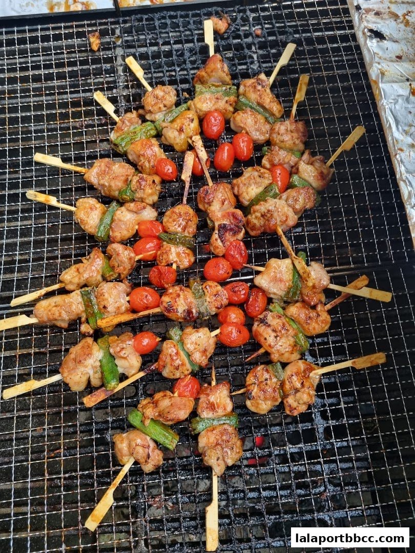 A close-up shot of grilled skewers with meat, cherry tomatoes, and green peppers on a grill.