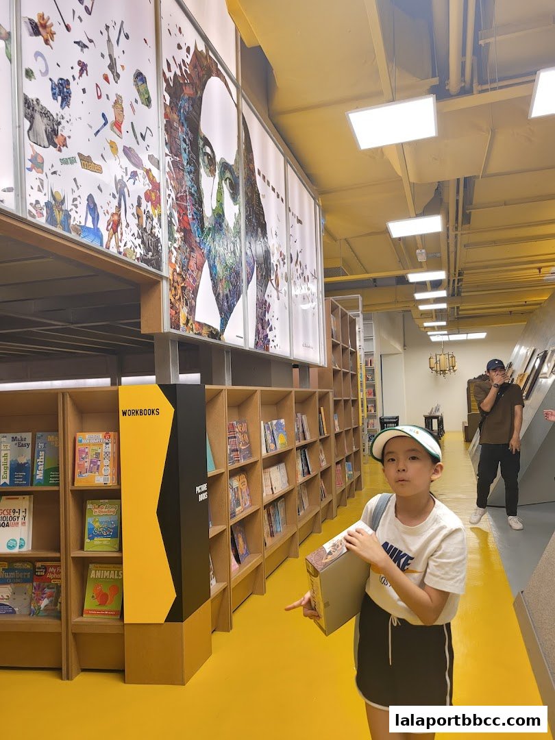 A child points at shelves filled with books and artwork on the walls in a brightly lit store.
