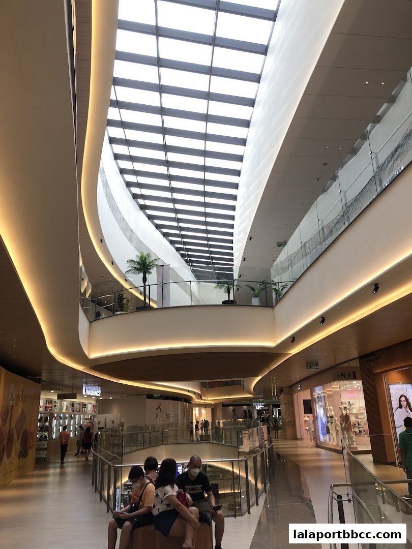 Interior view of a modern shopping mall with a large skylight and multiple levels.
