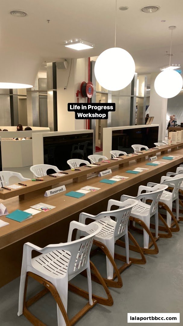 A long table with chairs set up for a workshop, with 'Reserved' signs on the table.