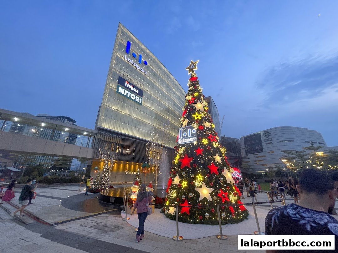 A festive Christmas tree stands outside a modern shopping mall with 'LaLaport' signage.
