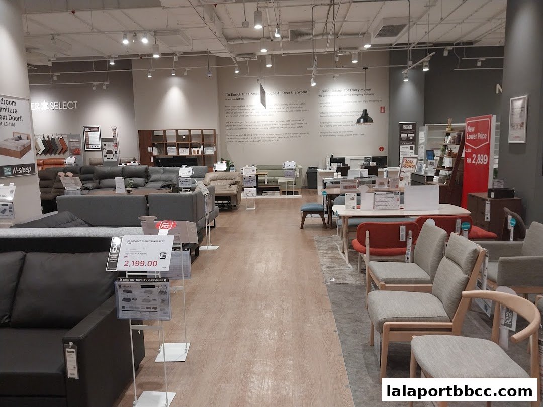 Interior view of a NITORI furniture store showcasing various sofas, chairs, and bedroom furniture.