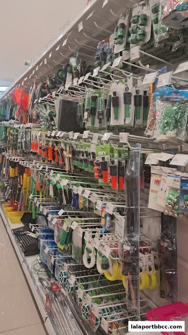 Shelves stocked with various gardening and DIY tools, including hoses, connectors, and sprayers.