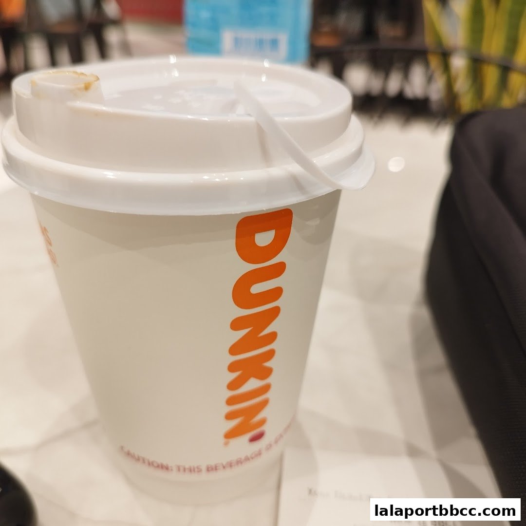 A close-up of a Dunkin' Donuts branded cup with the logo visible.