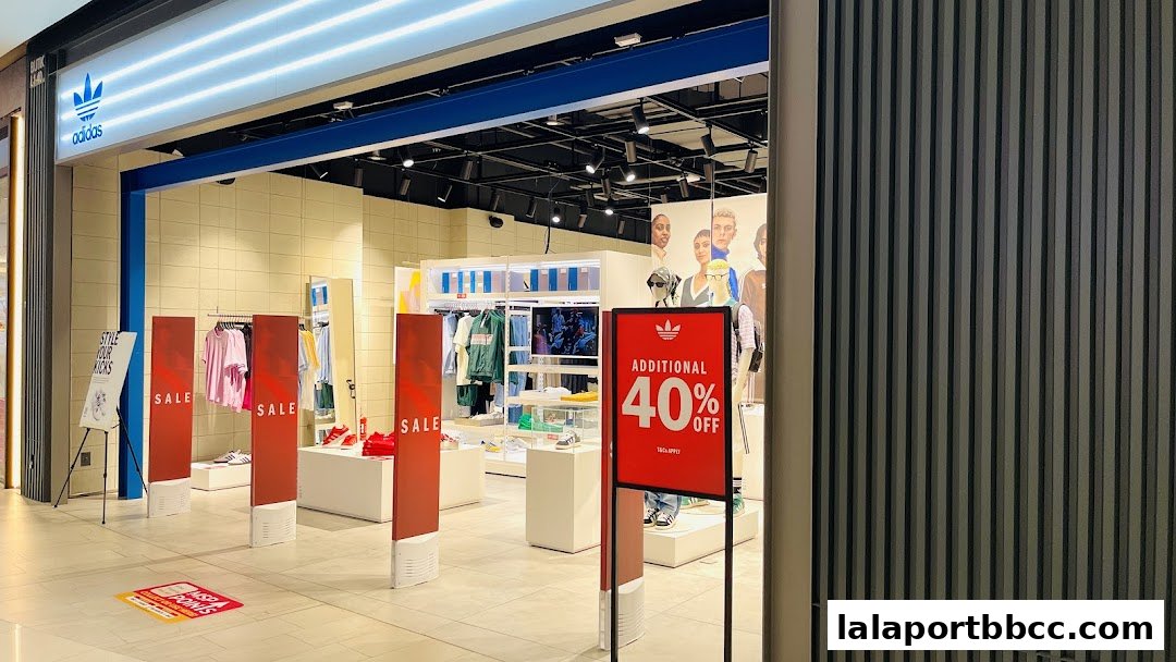 Adidas Originals store entrance with sale signs and merchandise displayed.