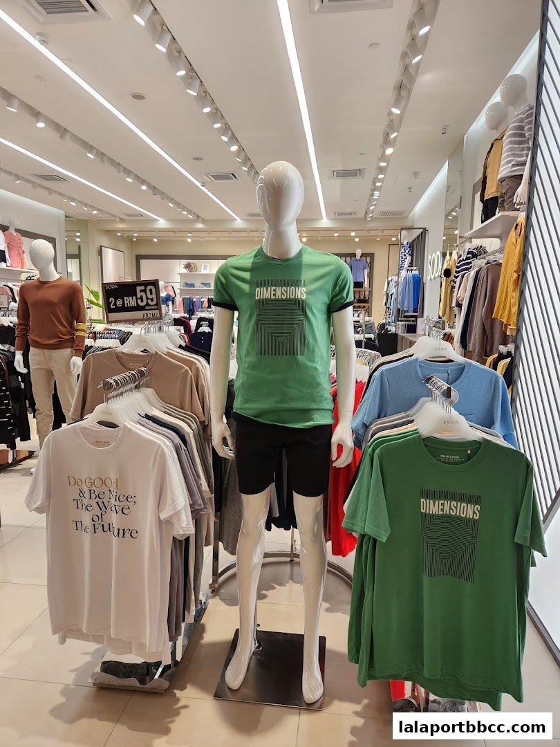 Mannequins display t-shirts with graphic prints and text in a brightly lit clothing store.