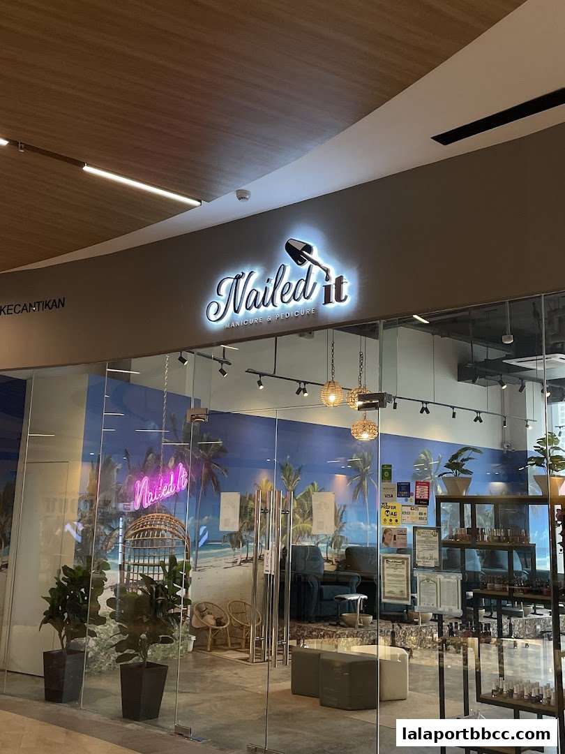 The entrance of Nailed It Manicure & Pedicure salon with a tropical beach mural.