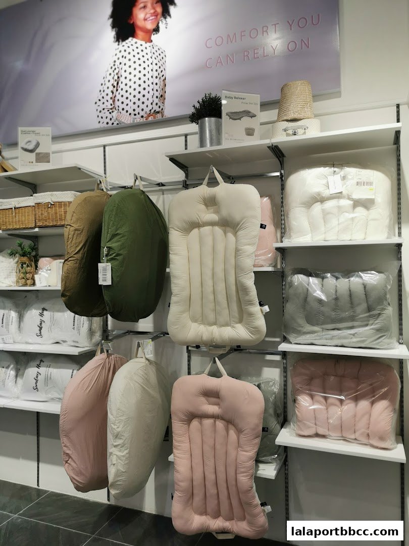 A display of baby loungers and relaxers in various colors on shelves.