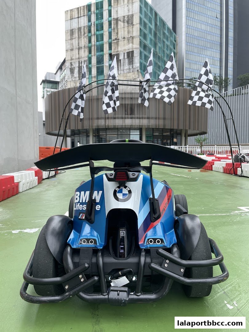A go-kart with BMW branding on a race track with checkered flags.