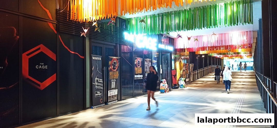 The entrance to 'The CAGE - Duel Dine' with vibrant decorations and people walking by.