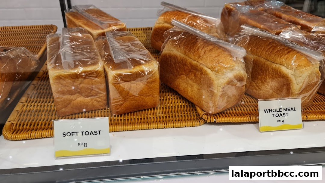 Freshly baked loaves of soft toast and whole meal toast are displayed in clear packaging.