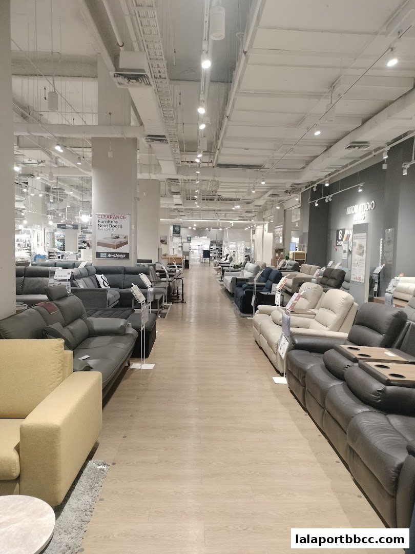 A wide aisle in a furniture store showcasing various sofas and recliners.