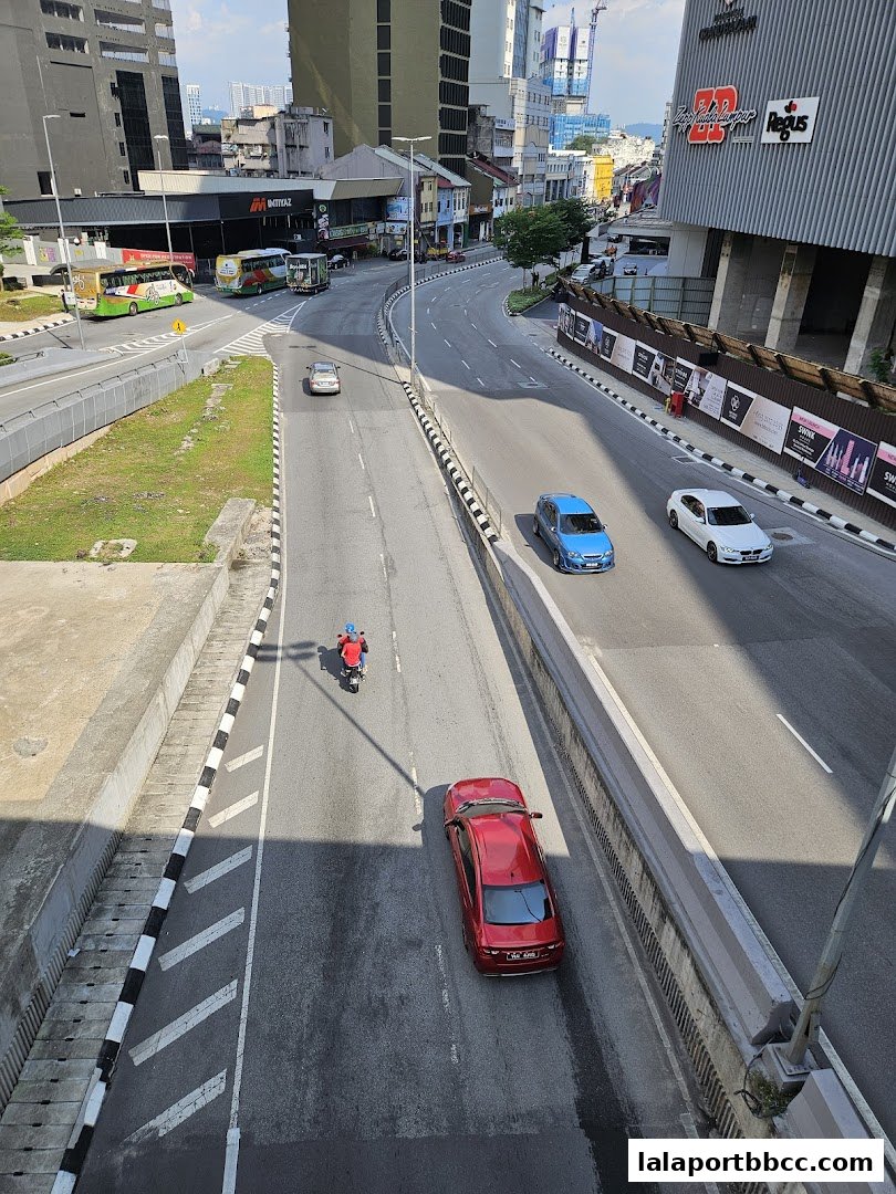 An aerial view of a busy street with cars and a motorcycle in Kuala Lumpur.