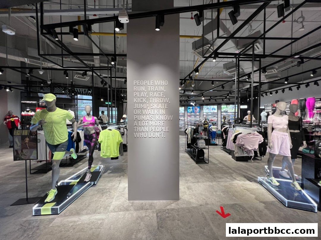 Interior view of a PUMA store with mannequins displaying athletic wear and motivational text on a pillar.