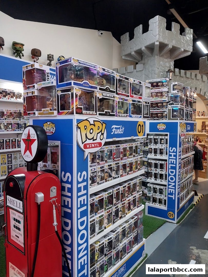 Interior of a toy store featuring shelves filled with Funko Pop vinyl figures and a vintage gas pump.