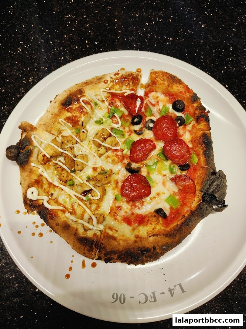 A delicious half-and-half pizza with chicken and pepperoni toppings on a white plate.