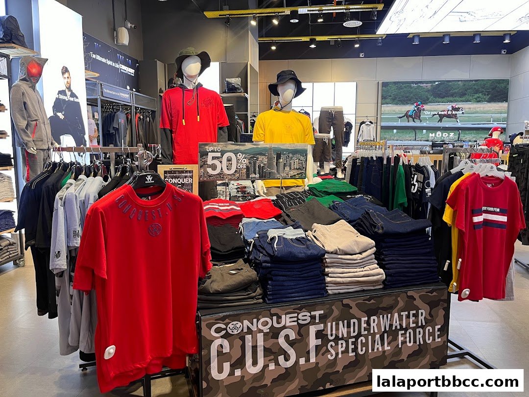 Interior of a clothing store showcasing folded jeans, t-shirts, and mannequins wearing casual wear.